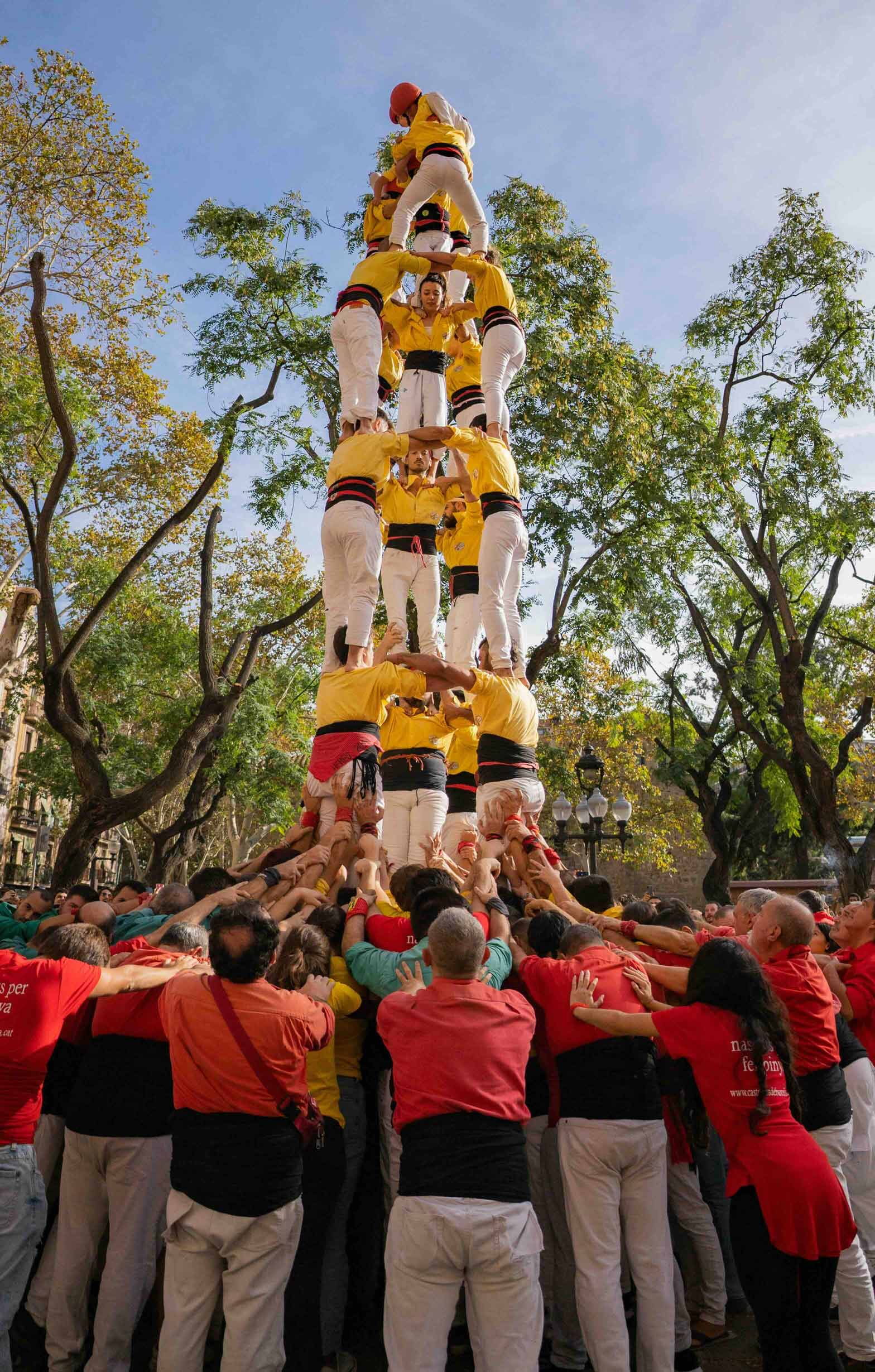 Image of a group of castellers forming a human tower. The pinya (base) metaphorically represents the cooperative core that supports the most dynamic relationships of the tower. Imatge inicial - Image of a group of castellers forming a human tower. The pinya (base) metaphorically represents the cooperative core that supports the most dynamic relationships of the tower.